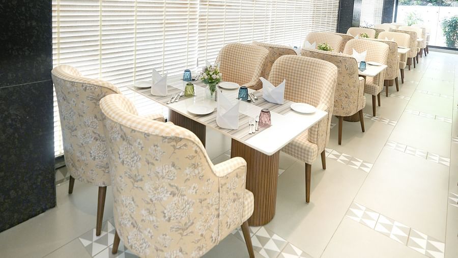 An image of dining tables positioned beside a window, with the windows covered by curtains - NAMAMI BY ZENQ BANKHANDI