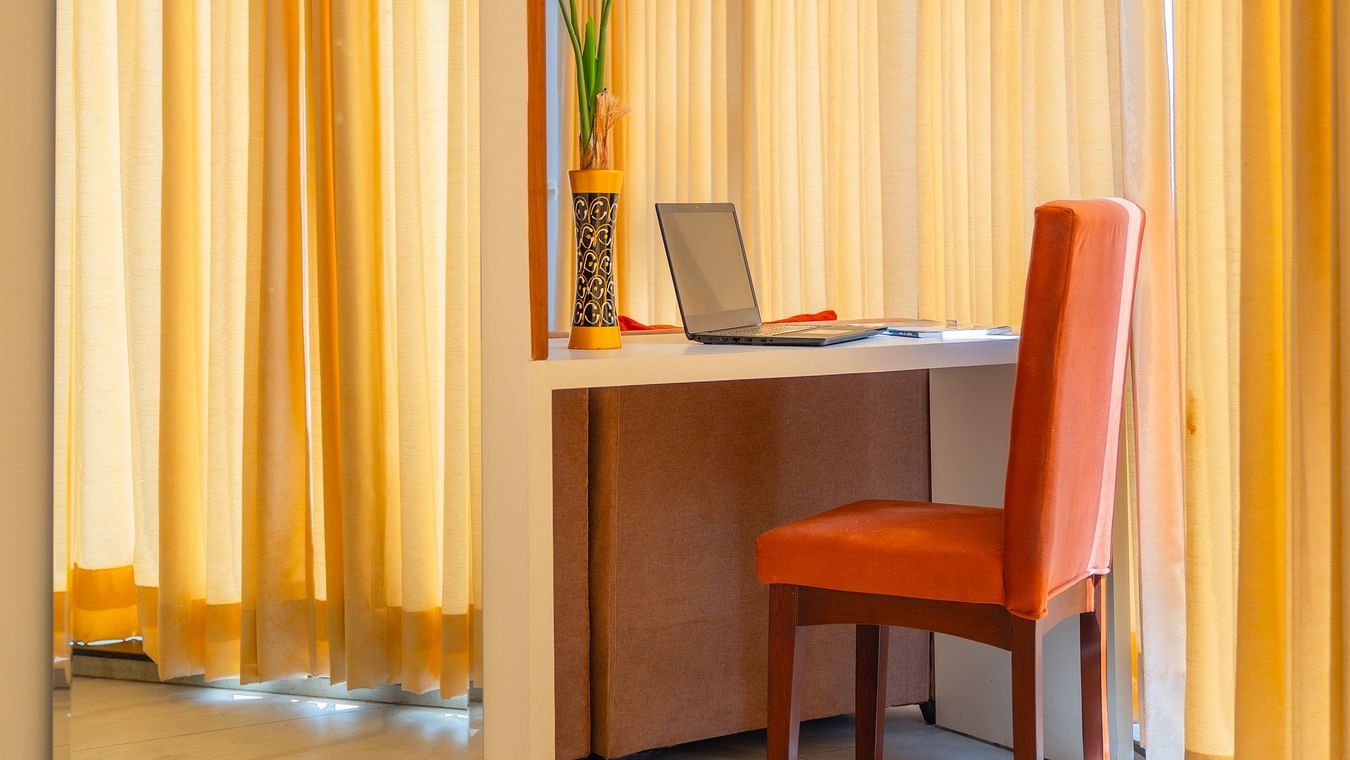 A work desk and chair placed next to a mirror in a Standard Room at Montclair Ananta, Elite.