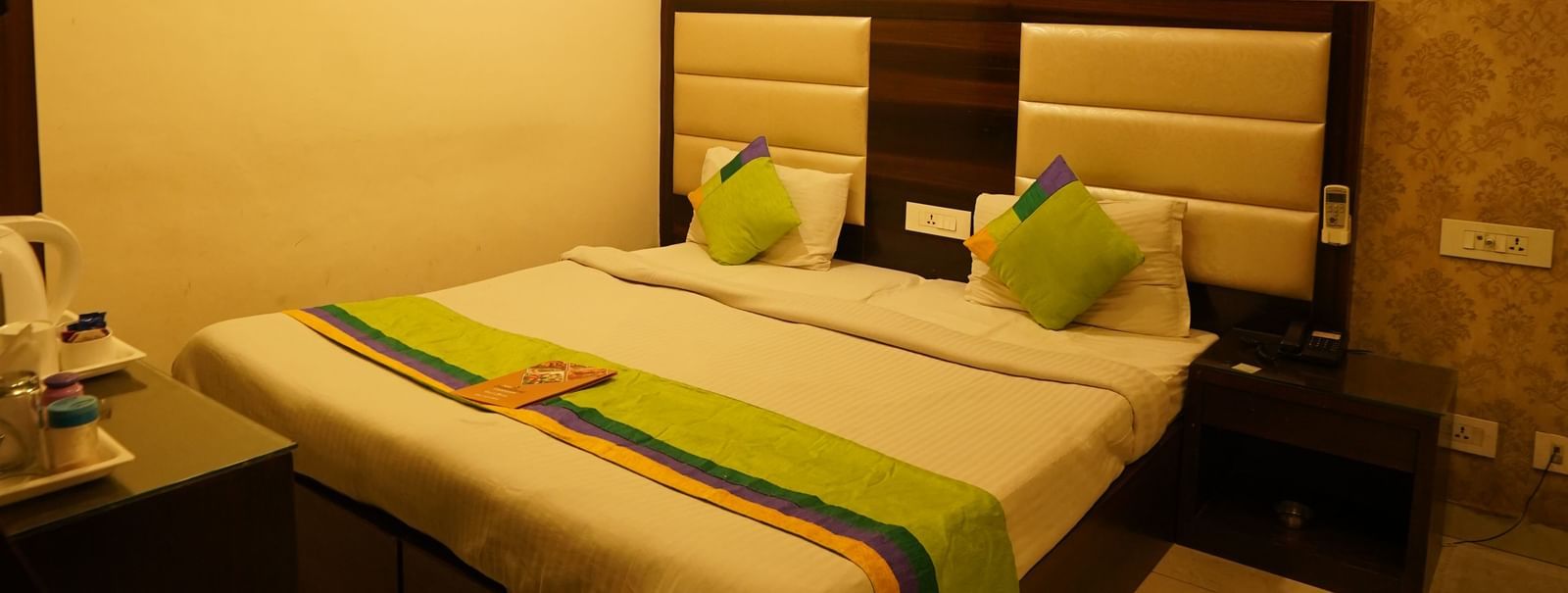 Portrait view of Standard Room with King-size bed facing a TV, wooden wardrobe, air-conditioning and marble-flooring at  Hotel Dreamland, Chandigarh