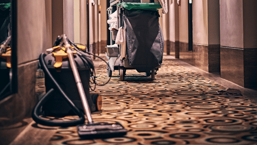 a vacuum cleaner and other room service supplies outside a hotel room