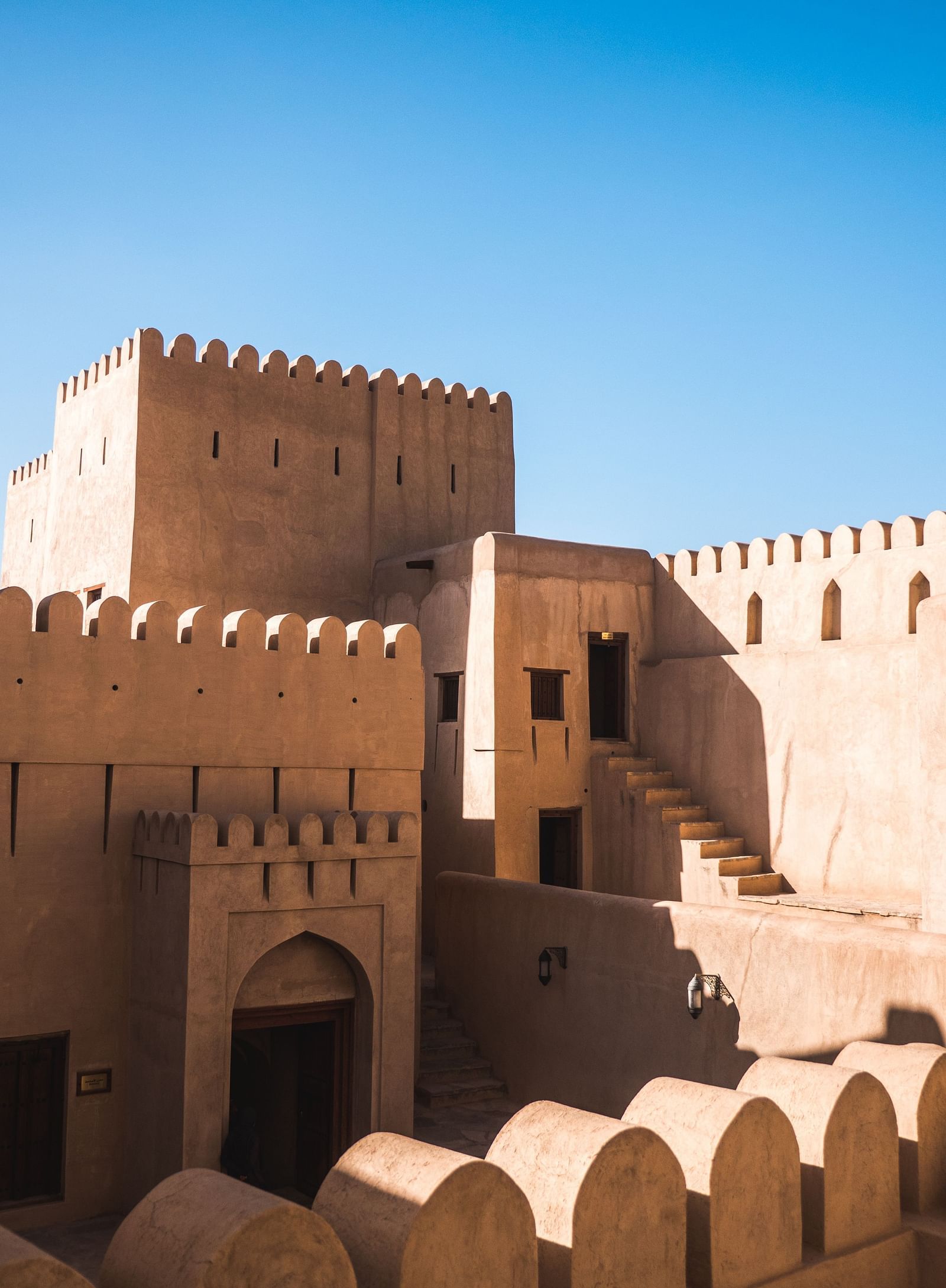 A fort with doors and steps leading to different rooms inside and the blue sky in the background