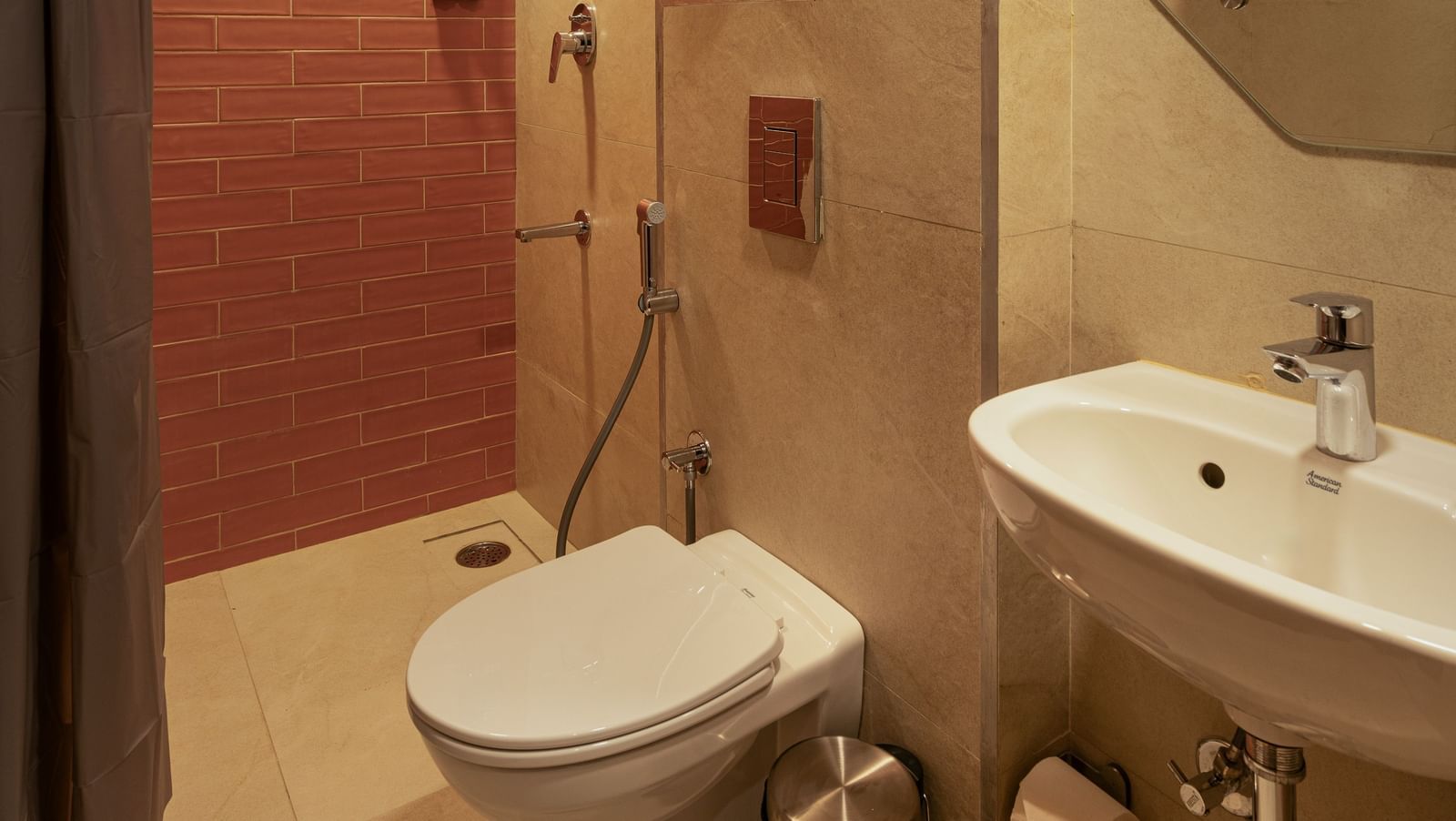 washroom with white tiles and sparkling clean washbasins and circular mirror.