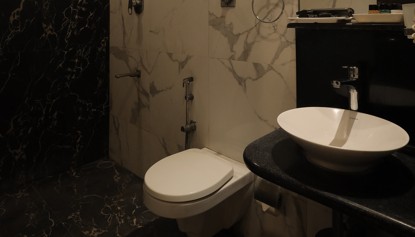 An image of a western style bathroom with sink, faucet, and other bathrom toiletries - Sathyam Grand Resort