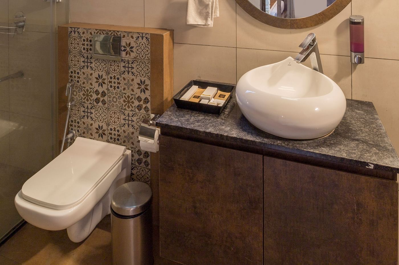 Modern bathroom with round mirror and elegant sink at Nirantara Resort 