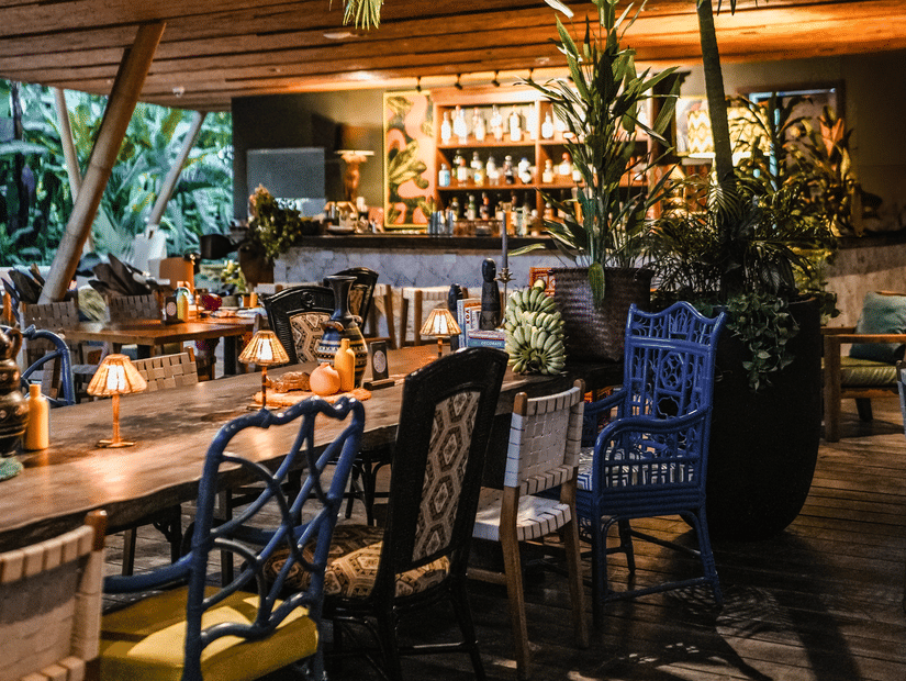 Indoor dining area with tall indoor palms and blue chairs at Lamari Siargao.