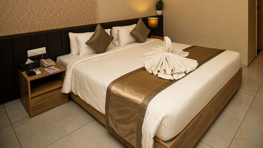 Spacious king-sized bed with a bedside lamp and table with a telephone