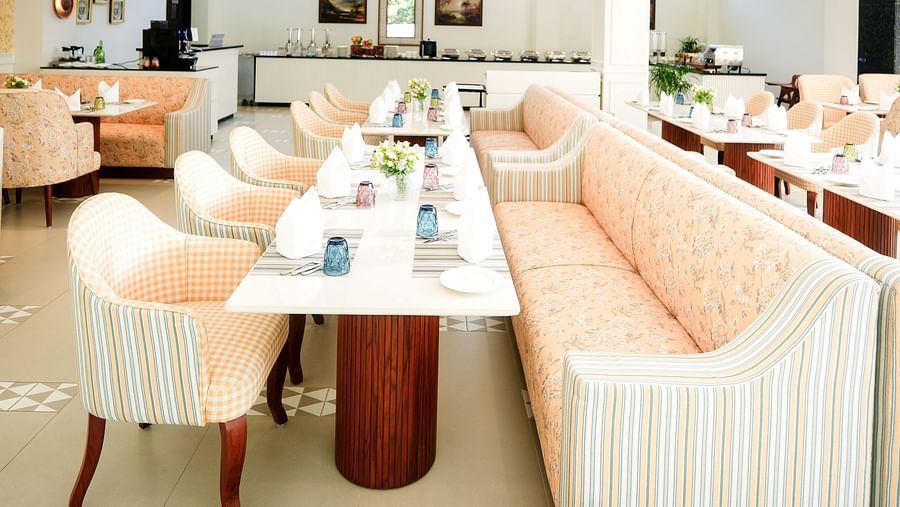 An image capturing our restaurant with patterned tile flooring, featuring upholstered chairs and sofas arranged around the dining tables - NAMAMI BY ZENQ BANKHANDI