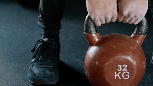 a man lifting a weight at a gym 