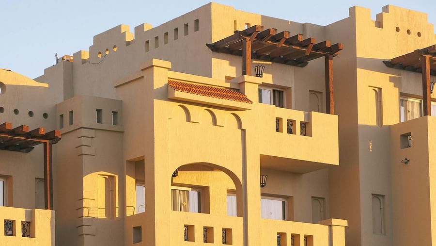 a facade image of the hotel with a swimming pool