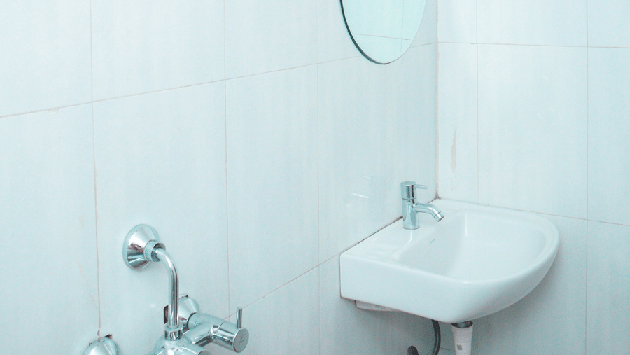 A bright bathroom featuring a wash basin along with a circular mirror above it at Dip Holidays.