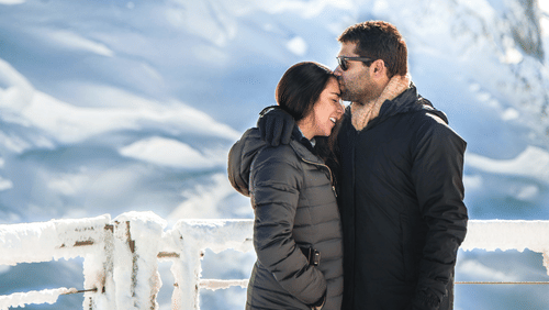 A couple with snow-capped mountains in the background
