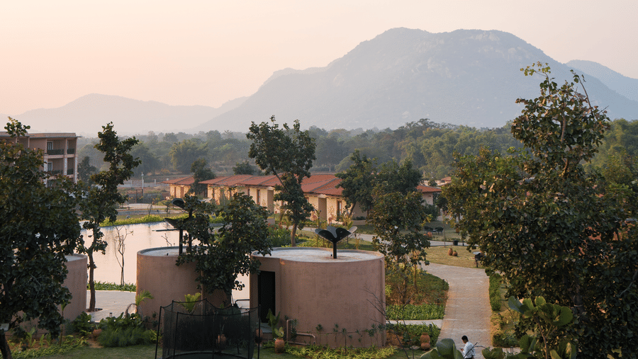 A vertical landscape view featuring a pathway, trees, and a hazy mountain in the distance at Hotel Sonar Bangla, Ajodhya Hills.