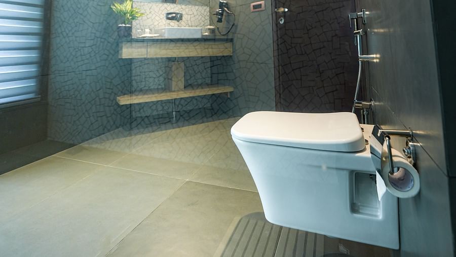 An brightly lit washroom of our suite in Bankhandi with a commode, a large sink and wall-mounted mirror - NAMAMI BY ZENQ BANKHANDI