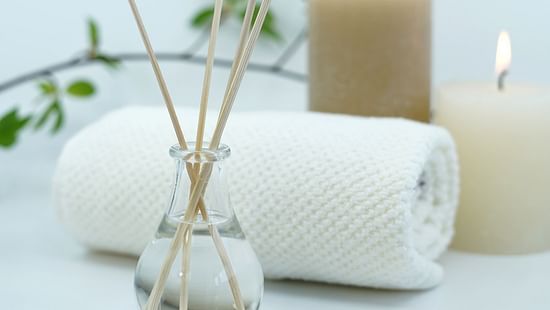 a desk containing a towel, lit candles and incense sticks