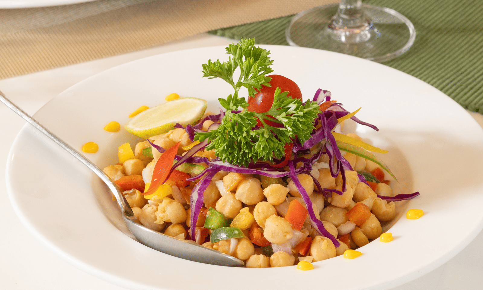 A close-up of a dish topped with fresh herbs, beside a glass of orange juice - Megha Resort & Villas, Dehradun