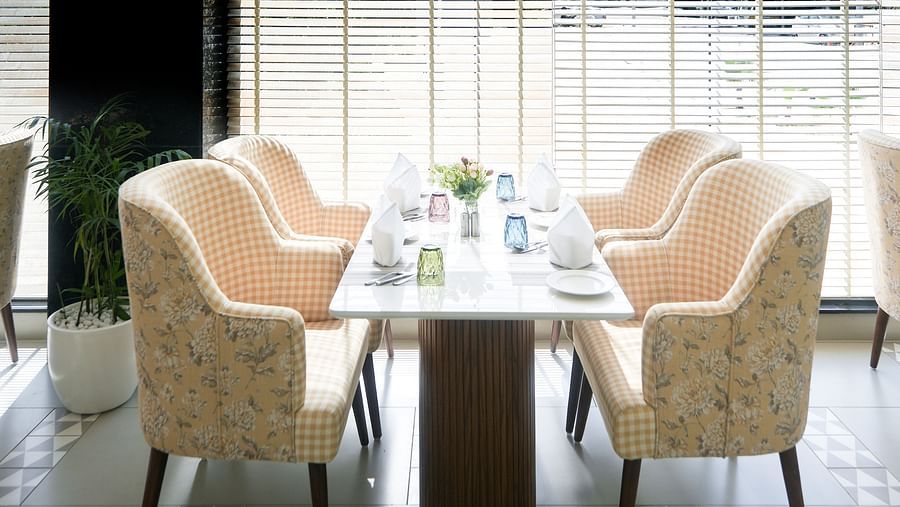 A restaurant with a table positioned near a floor-to-ceiling window, illuminated by soft lighting throughout the space - NAMAMI BY ZENQ BANKHANDI