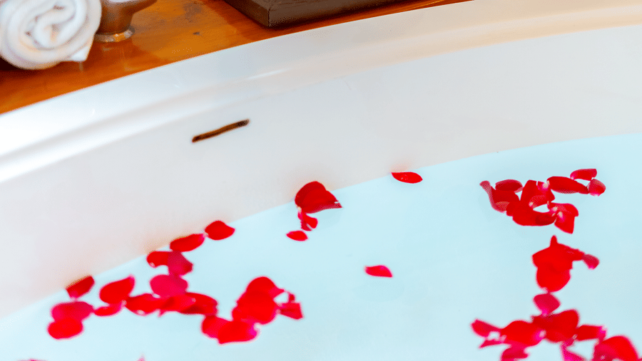 A high-end soaking tub filled with water and floating red rose petals for a romantic spa experience - Johnson Lodge & Spa, Manali
