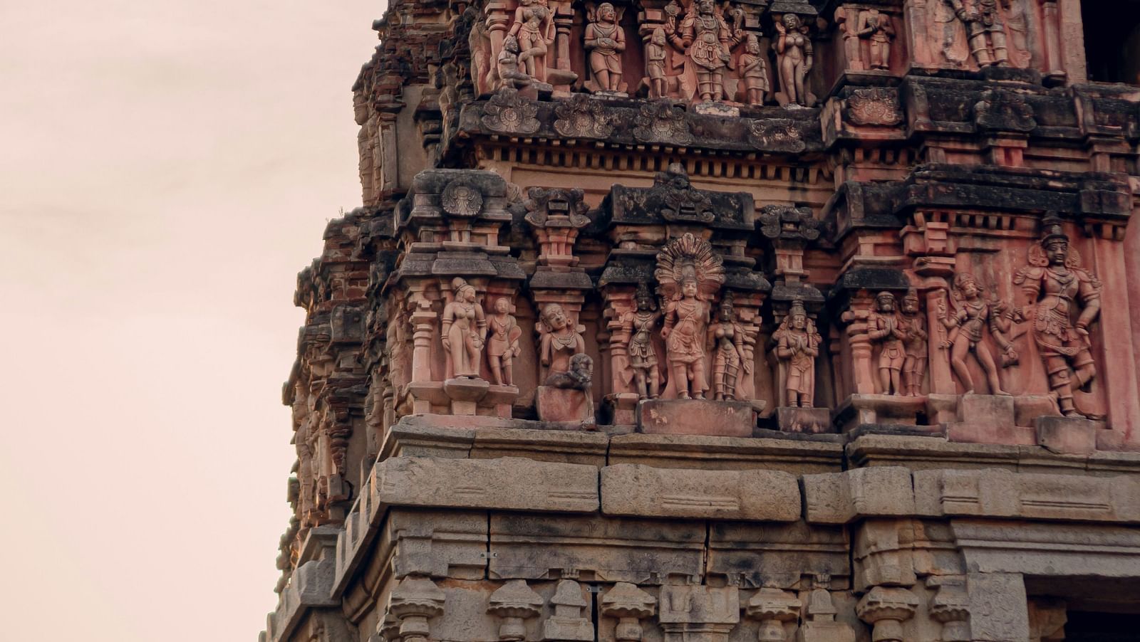 Ancient temple tower with ornate carvings against a dusky sky.