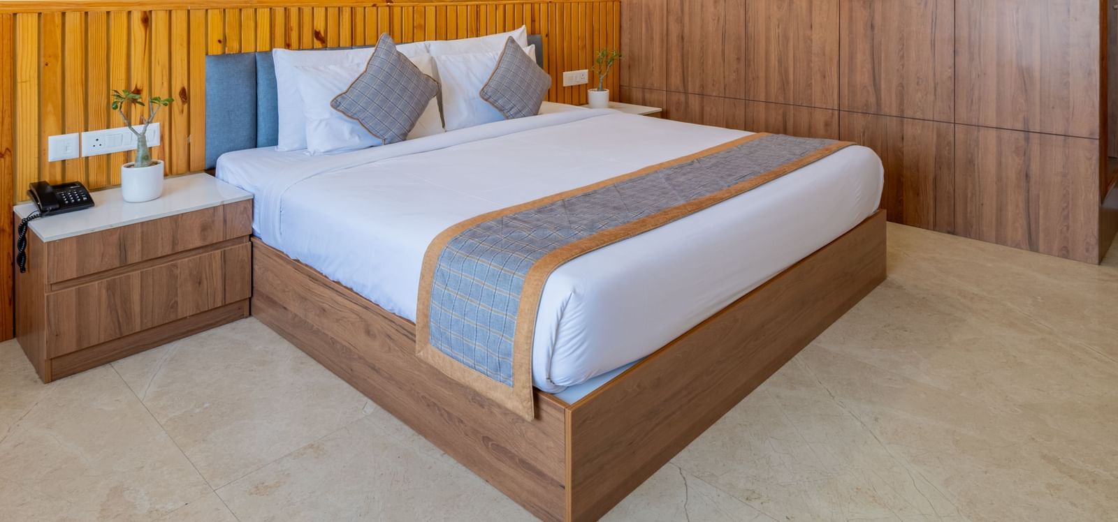 Deluxe room with wooden interiors, a king size bed, and a ceiling fan at Hotel Highway King, Bagru