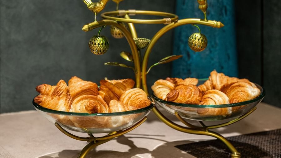 Flower arrangement with croissant displayed on a stand at Hotel Royal Regency Chennai