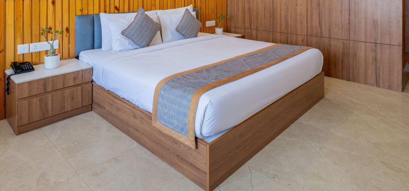 Deluxe room with wooden interiors, a king size bed, and a ceiling fan at Hotel Highway King, Bagru