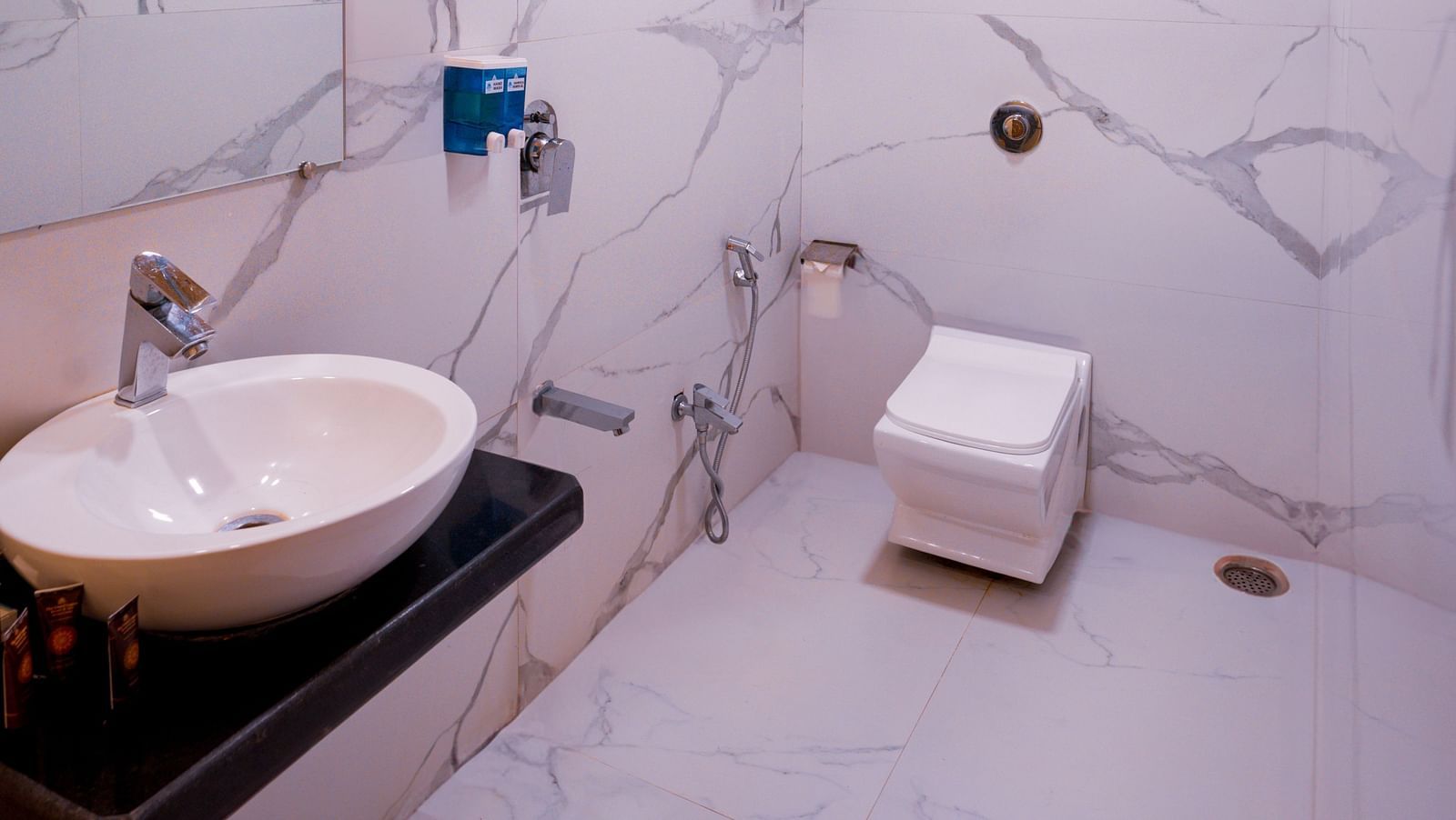 Image of a well equipped bathroom with a big mirror, a spot light, a white basin|  The Grand Legacy Resort and Spa
