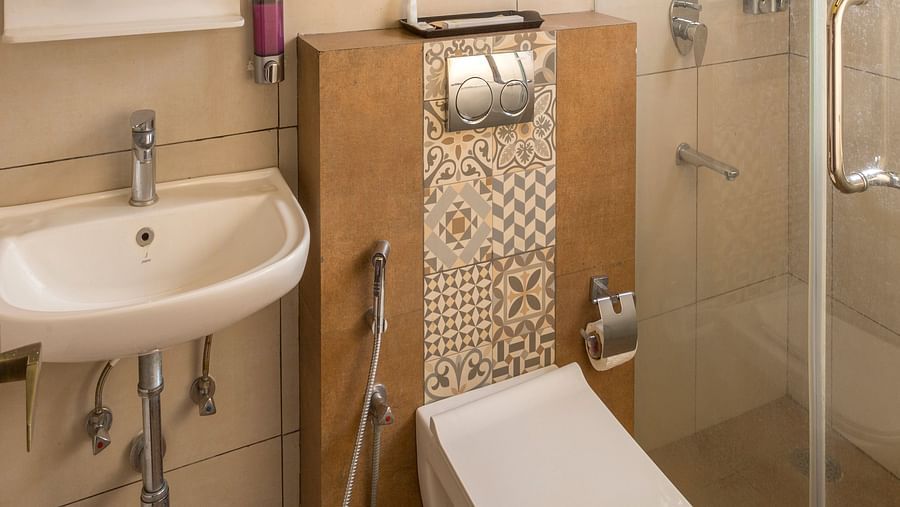 Bathroom with glass shower enclosure and wall mounted sink at Nirantara Resort & Spa