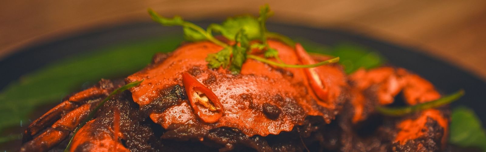 image of a crab preparation topped with green coriander leaf - Dip Holidays, Birbhum