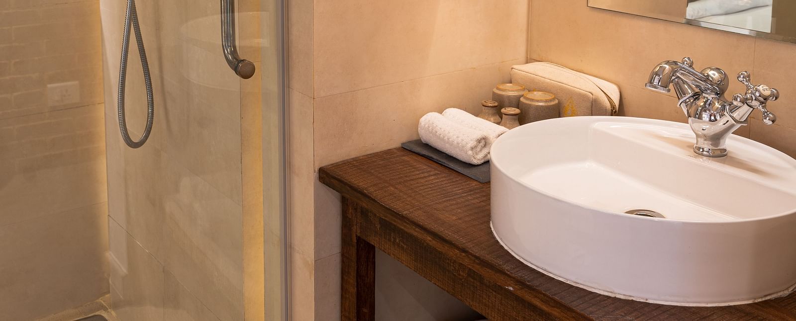 Washroom with a bamboo lamp hanging from the ceiling and toiletries - The Nanee