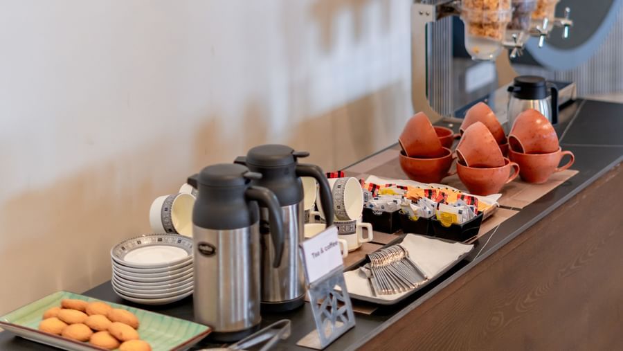 Close-up of a buffet station with juices, fruits, and pastries | Pravasa Hotel, Vijayapura