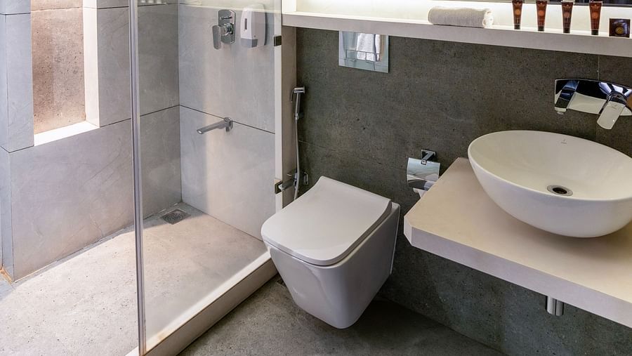 Image of a well equipped bathroom with a big mirror and  a white basin|  The Grand Legacy Resort and Spa