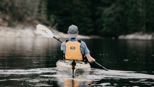 a man kayaking on the glistening water of the lake
