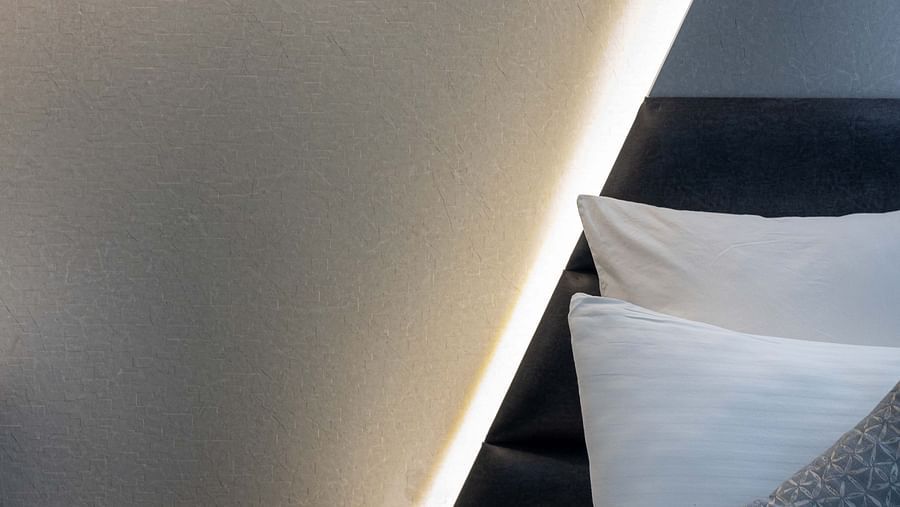 Image of Coral Premium Room at Coral Reef Hotel and Spa in Port Blair featuring a well-lit wall with lamp and lights behind the bed