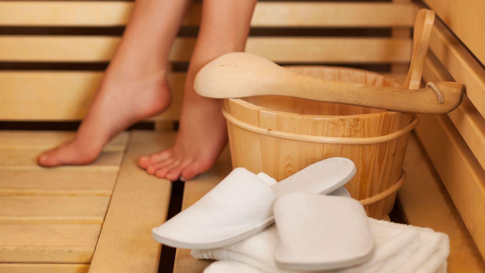 Close-up of a woman’s legs and slippers in a sauna - Cedar Inn, Darjeeling