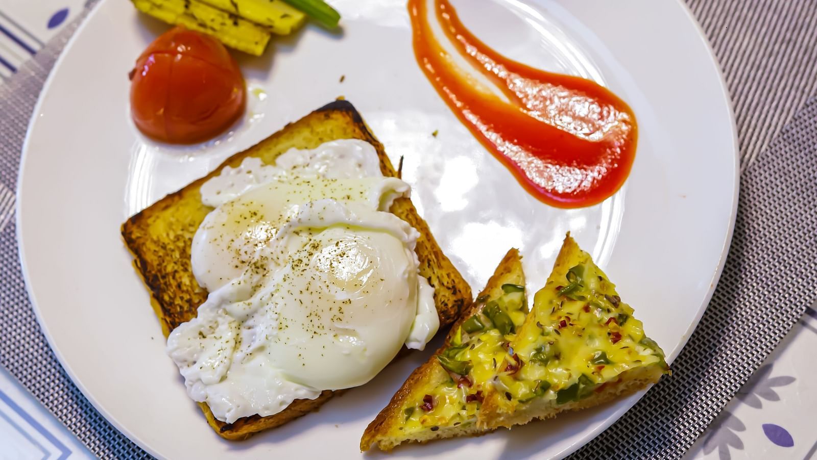 A plate with an open-faced sandwich and a drink sits on a patterned table at Vedikant Resorts The Mallard Corbett.