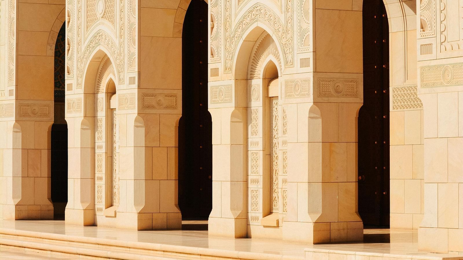 Elegant arches of a historic monument with intricate details and soft lighting.