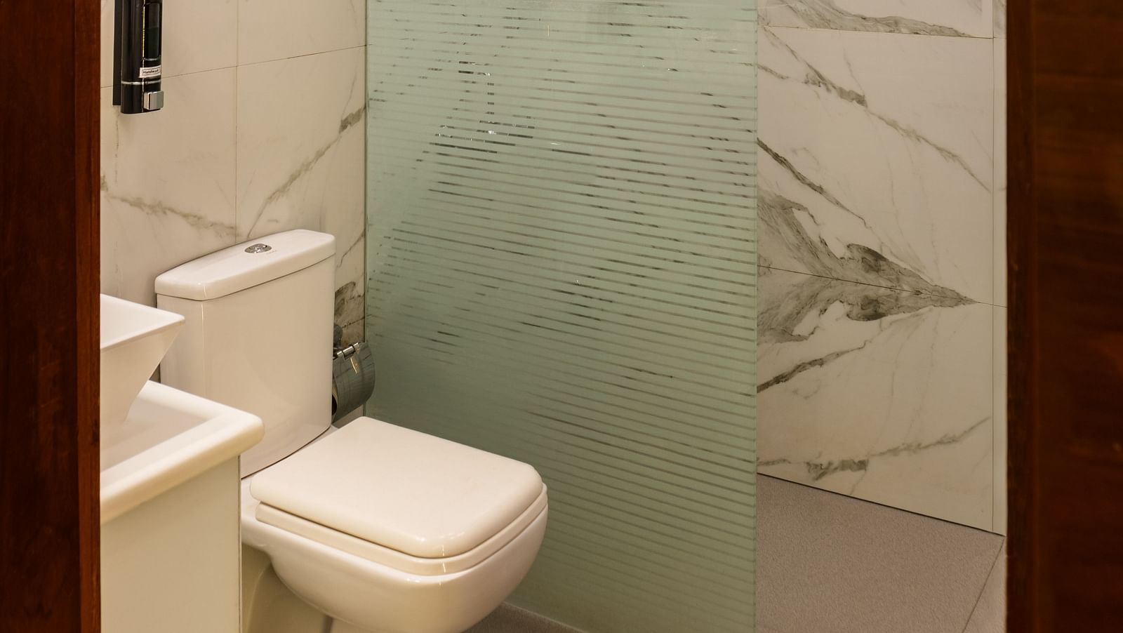 Bathroom of Lawn View Tent Room at The Grand Legacy Resort and Spa with frozen glass ceiling featuring a shower place separated by a glass door next to which is a toilet