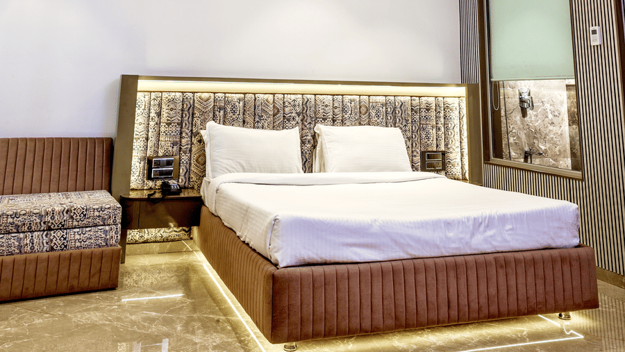 Room featuring a double bed, curved ceiling lighting fixtures, and a ceiling fan at Kumar Resort by Turtle.