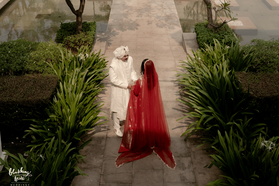 A married couple standing on the pathway set amidst the trees in Marasa Sarovar Premiere, Bodhgaya.