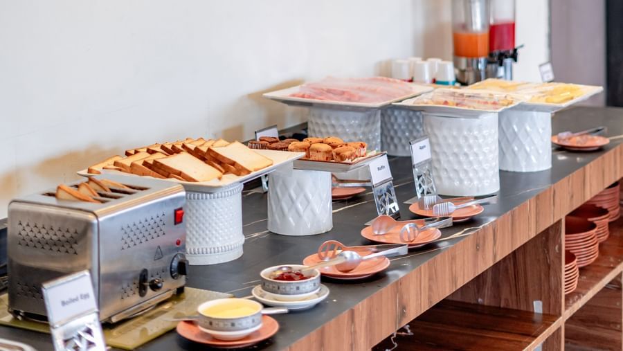 Side view of the buffet line showcasing various dishes and beverages | Pravasa Hotel, Vijayapura