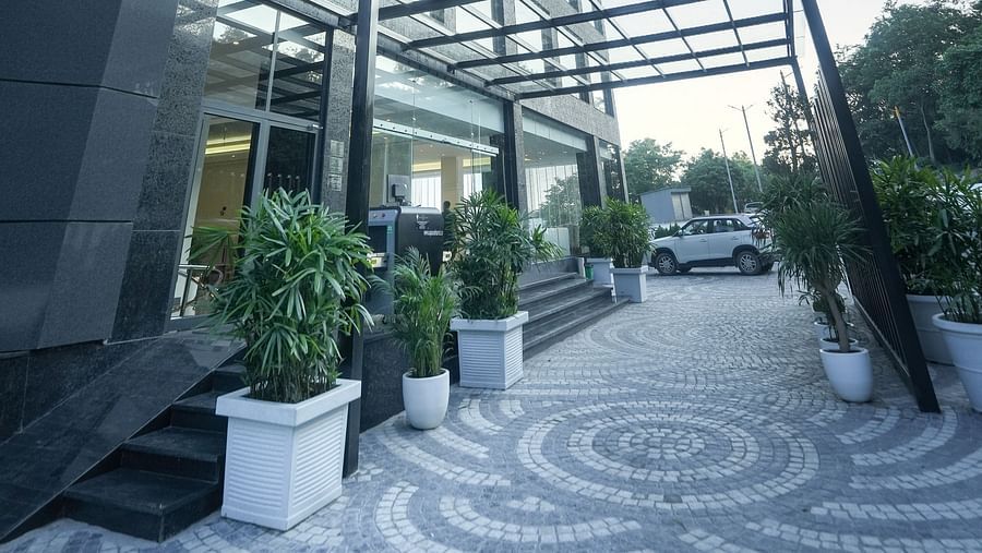 An image of a patterned pathway leading to the hotel entrance, flanked by potted plants on either side - NAMAMI BY ZENQ BANKHANDI