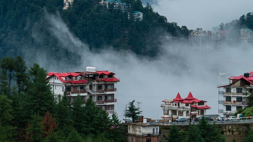 a few building in view in the foreground with mist covering behind it 