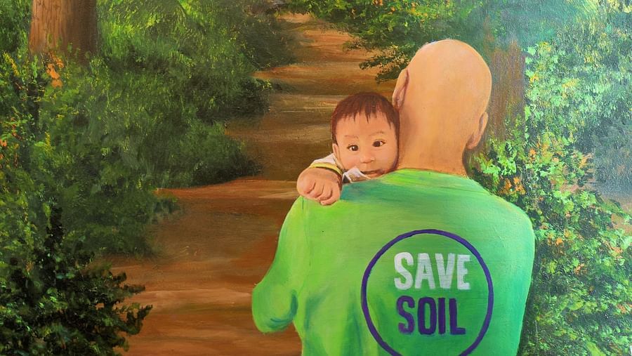 Picture of a man carrying baby, and Save soil text on the t-shirt - Karma Lakelands.
