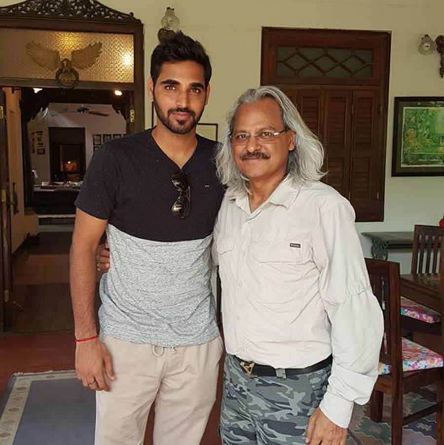  Image of  Cricketer Bhuvneshwar Kumar and a man posing for a picture inside a room with beautiful setting 