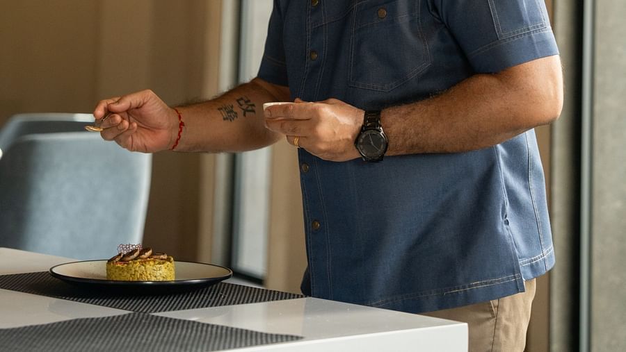 A chef garnishing the plated dish at Ananta Spa and Resort, Ajabgarh