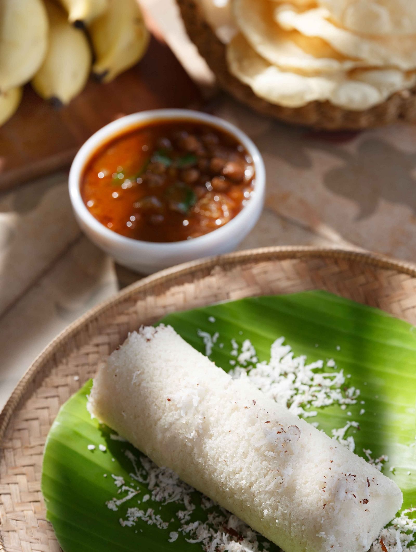 A close-up of a plate with food, possibly a wrap or roll with green sauce, along with other dishes.