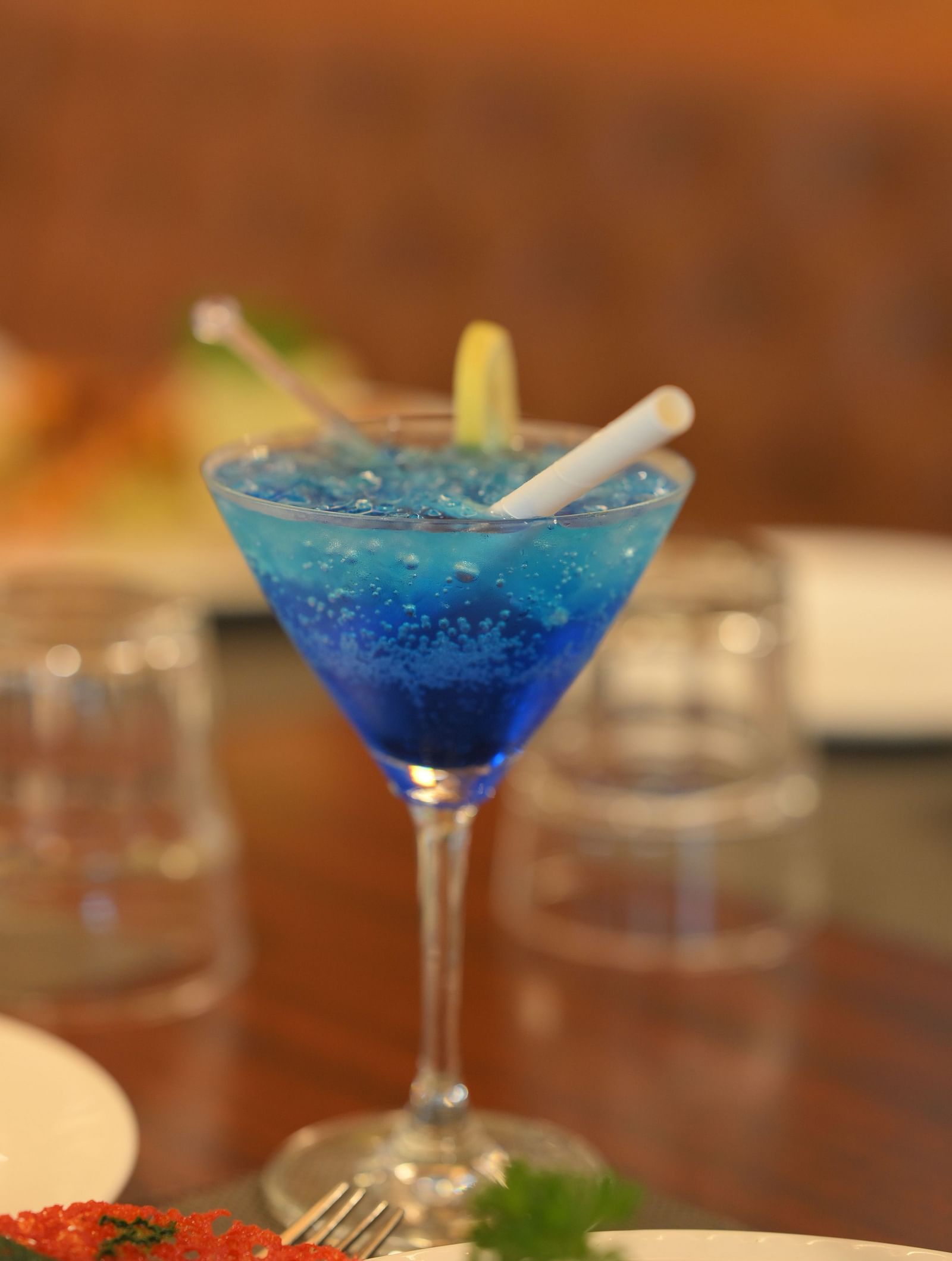 Refreshing blue mocktail garnished with citrus, served in a cocktail glass at Royal Comfort Regency, perfect for a relaxing evening.