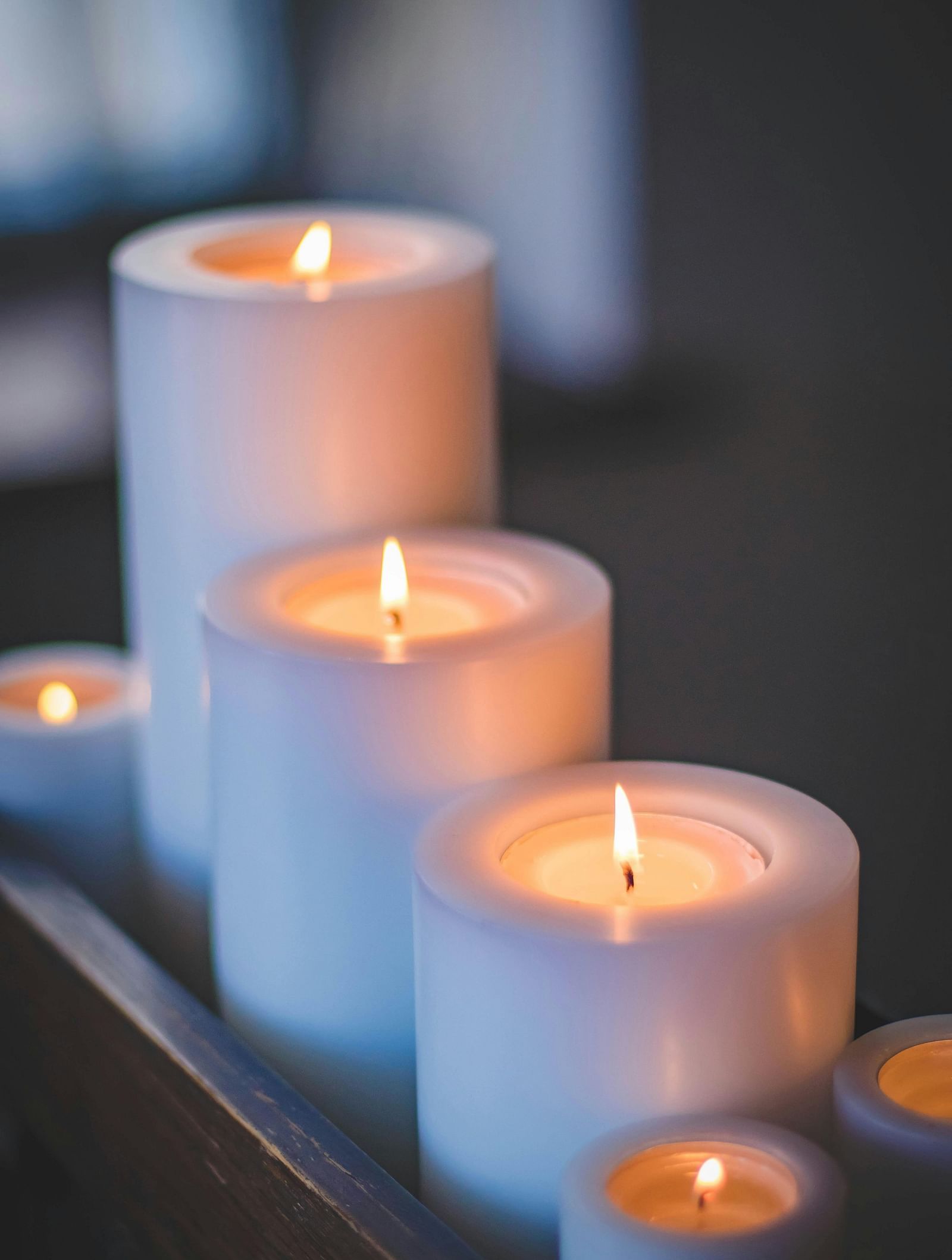 Lit candles set up on a table.