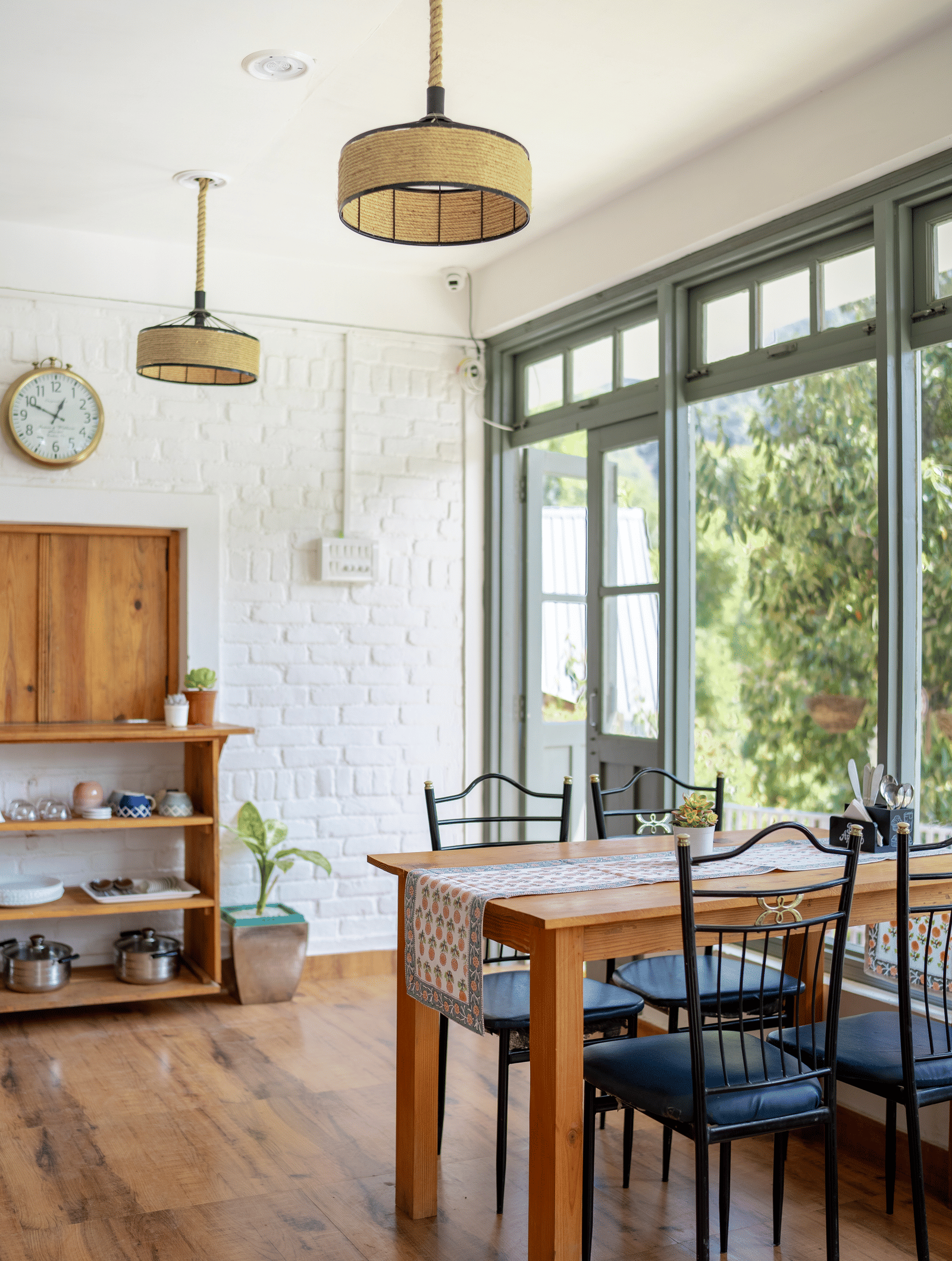 A dining table with chairs next to a window at Ziran Retreat.