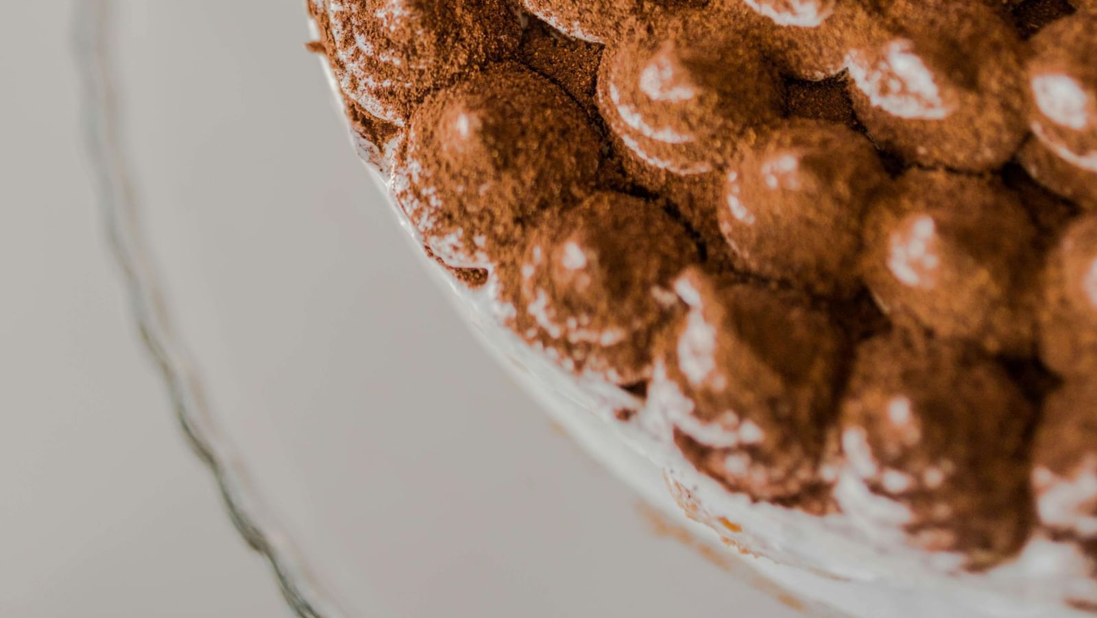 A plate of Tiramisu topped with cocoa powder.